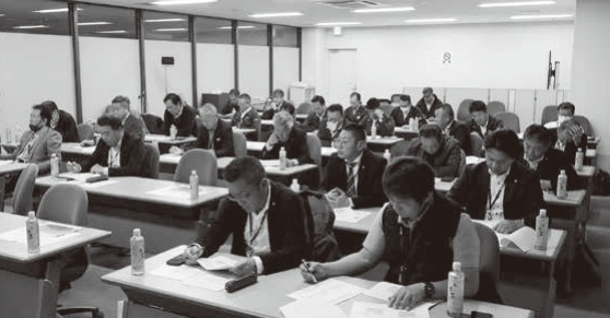 支部長会主幹による「決算勉強会」の会場風景と講師の植村亮太氏・金子統括支部長